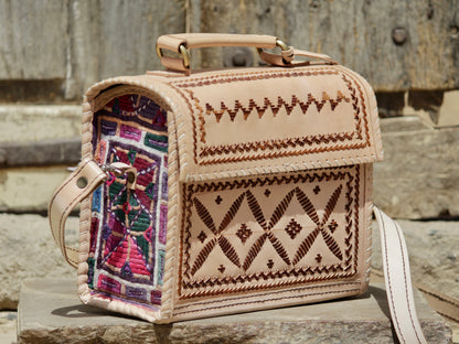Artisan-made leather hut bag featuring decorative thread embroidery on premium leather
