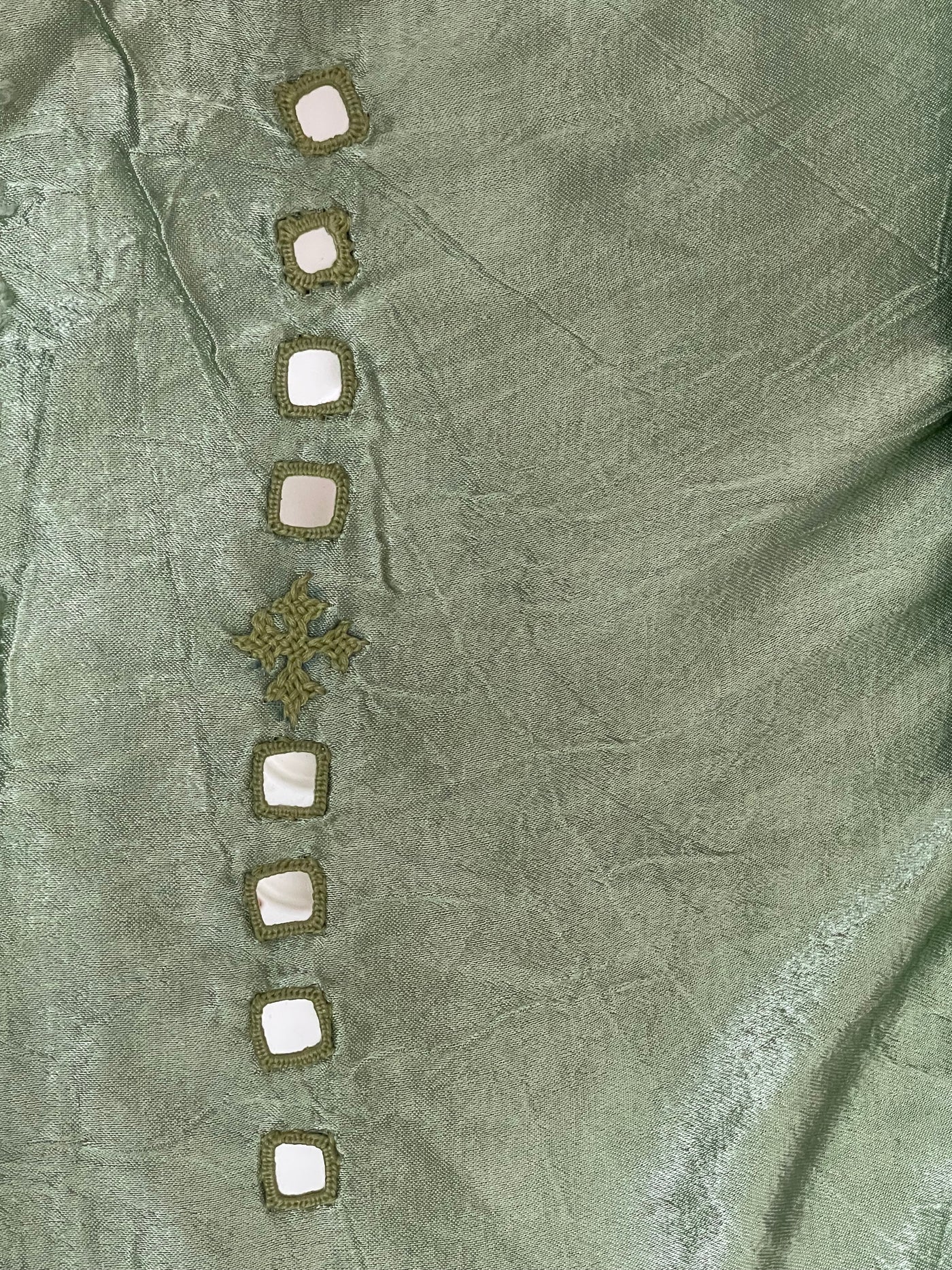 Soft green mirror work dress material showcasing intricate handcrafted embellishments