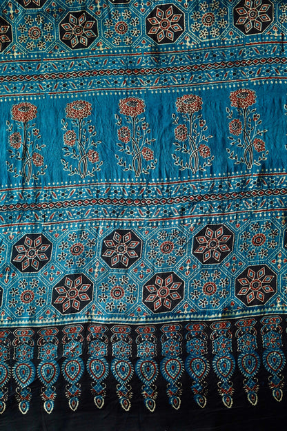 Turquoise blue Ajrakh modal silk saree featuring intricate hand block printed motifs and a graceful drape
