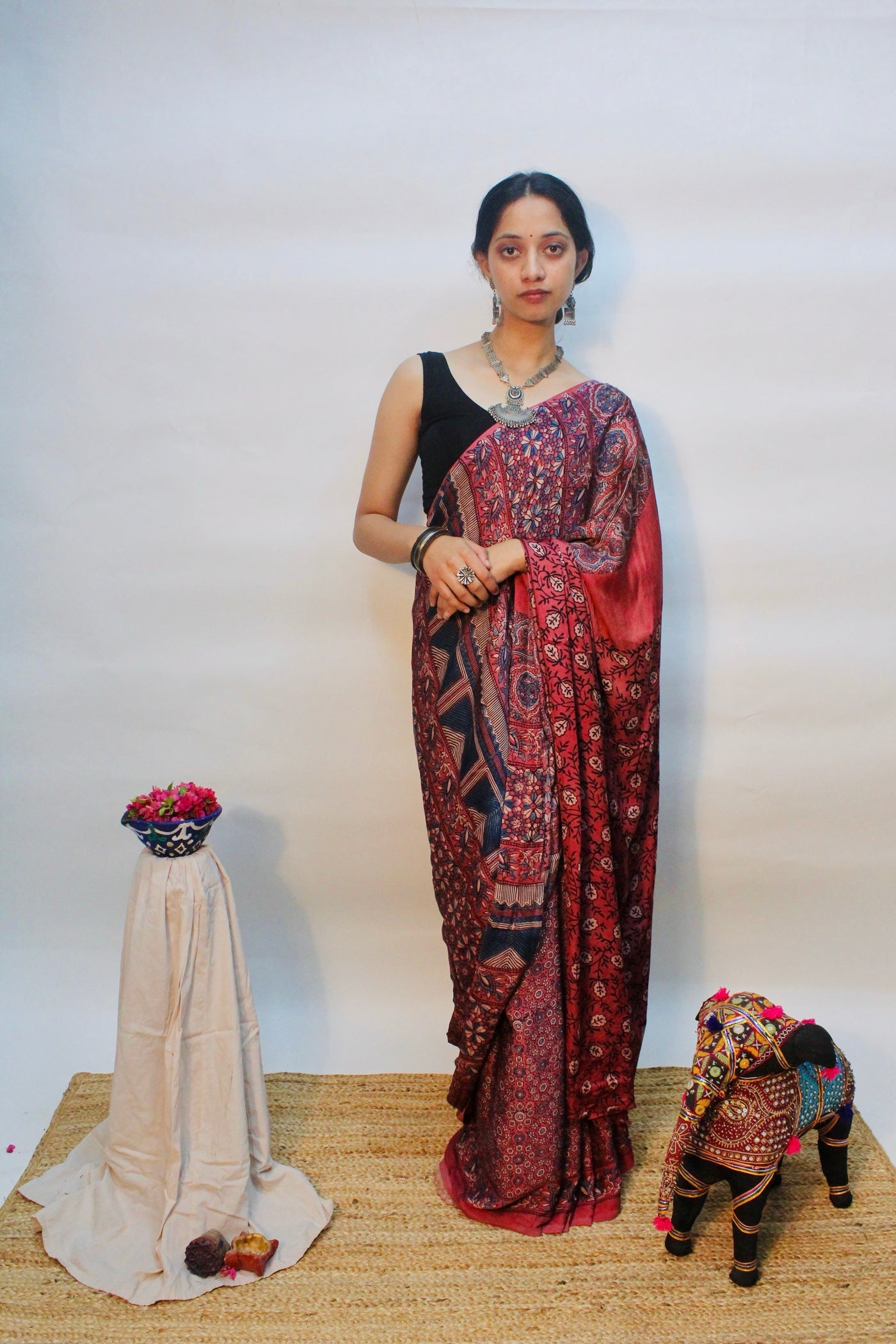 Wine pink Ajrakh modal silk saree featuring intricate hand block printed motifs and an elegant drape