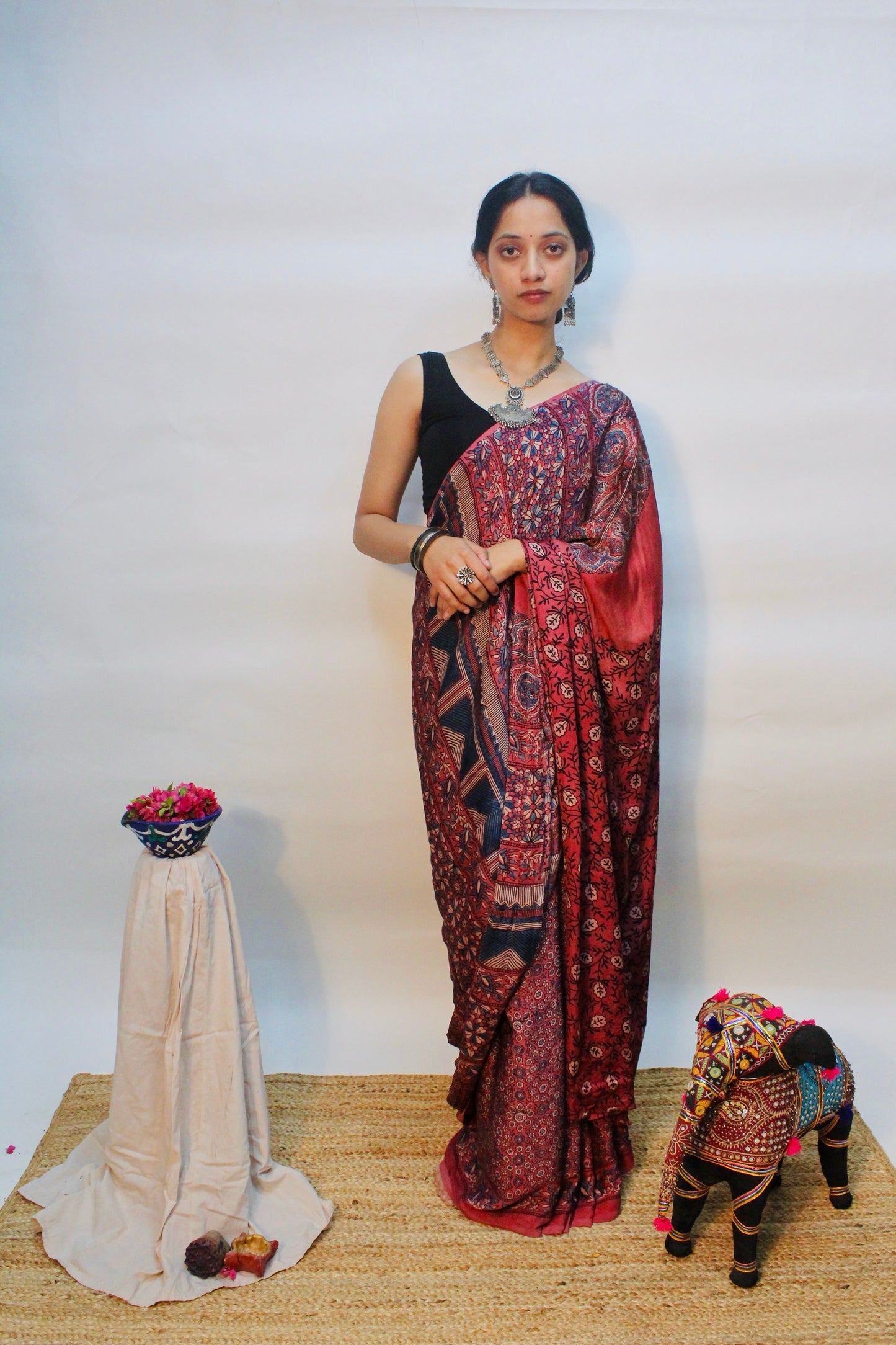 Wine pink Ajrakh modal silk saree featuring intricate hand block printed motifs and an elegant drape