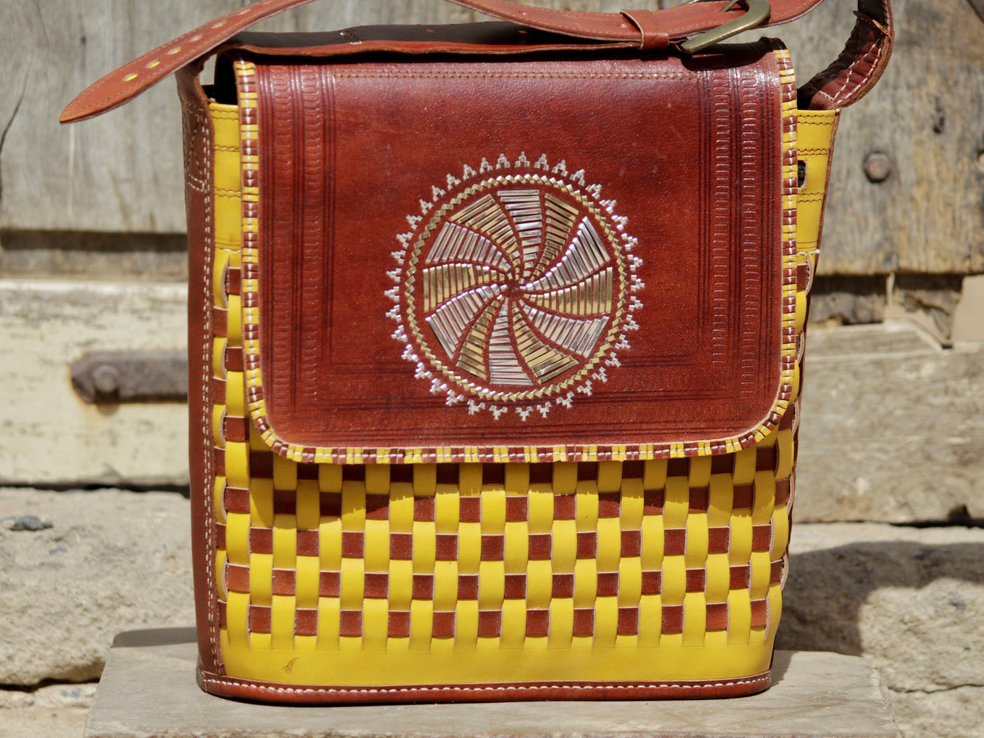 Premium leather bag combining durable leather construction with decorative zari work