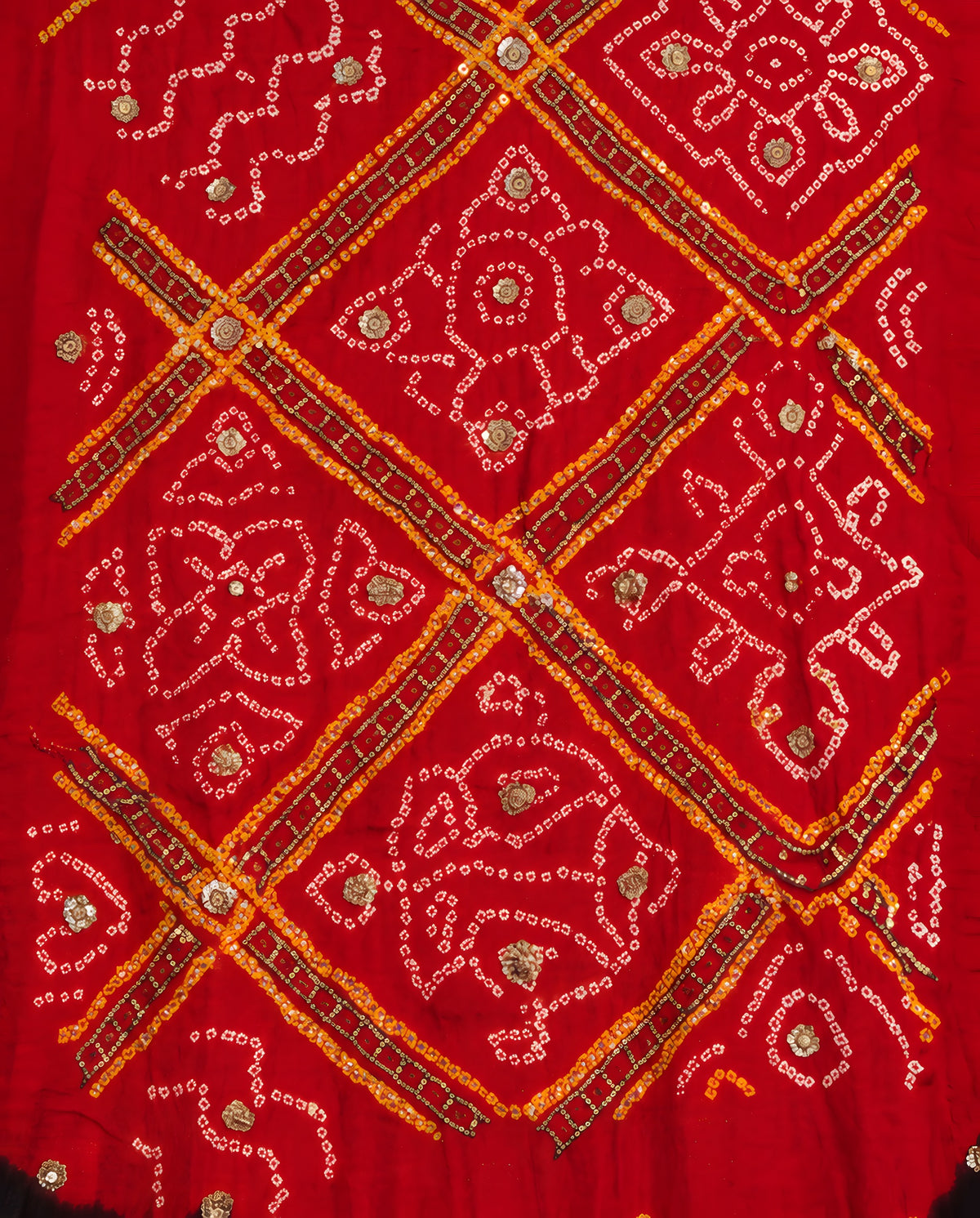 Close-up of gota patti work on black and red Bandhani dupatta